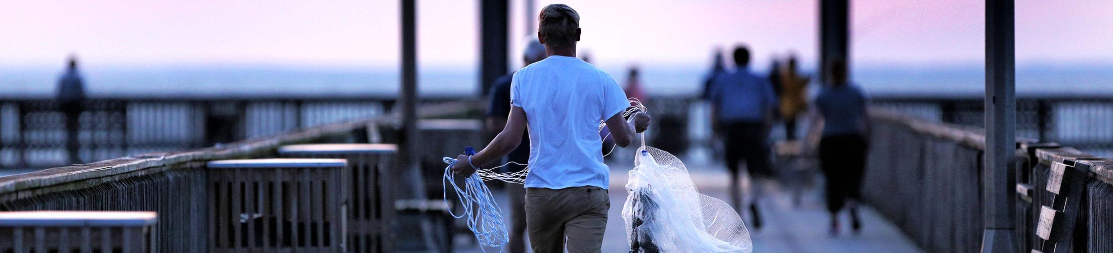Male carrying cast nets on Fair Hope Pier located on the Gulf Coast.