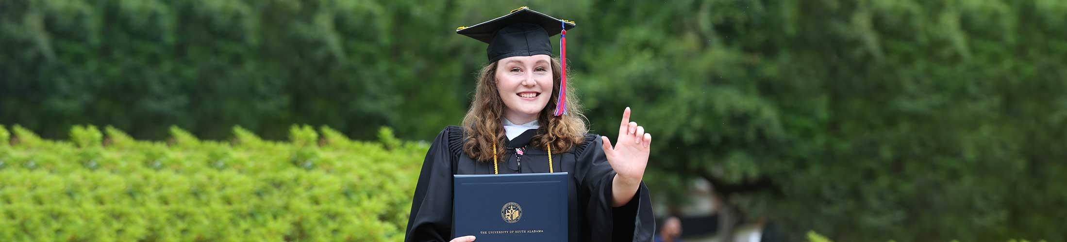 Student holding up J Sign at graduation