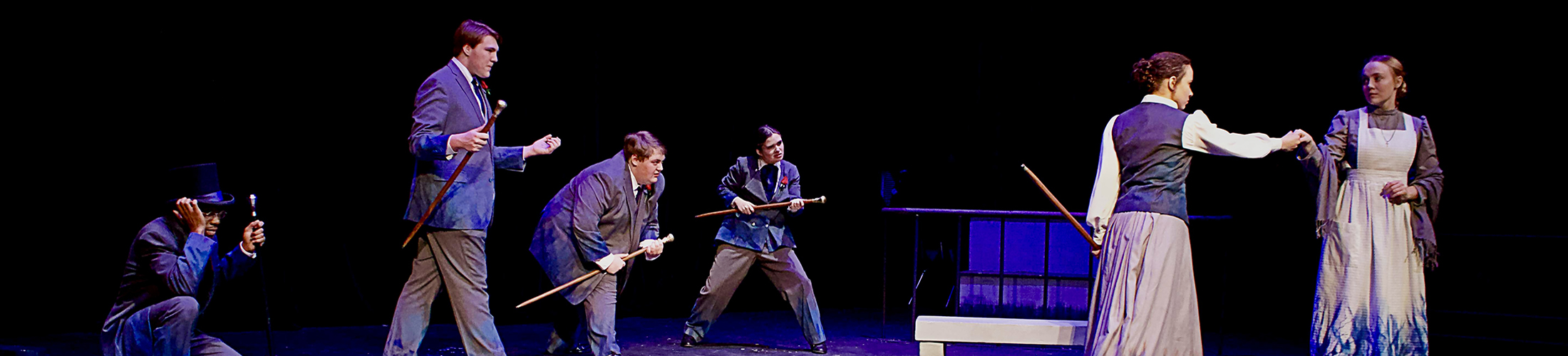 Students acting in a play on stage.